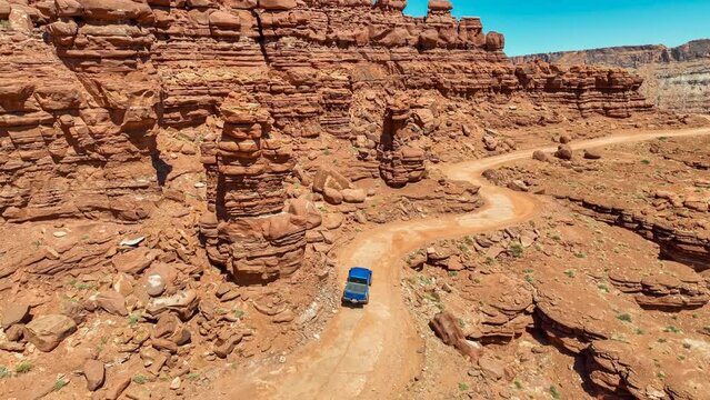 Aerial view of an off-road vehicle driving on a mountain trail in Moab, UT on a sunny spring day