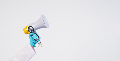 Doctor's hand wear latex glove and hold Megaphone and stethoscope on white background.