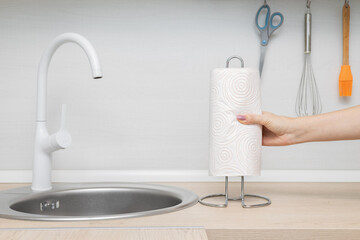 man inserting paper towel into holder in kitchen