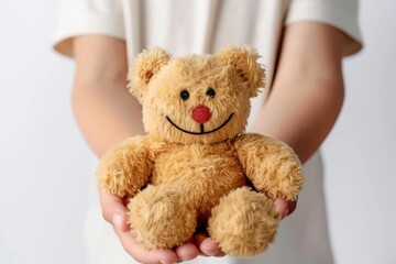 Person holding white toy teddy bear with happy smile on sleeve
