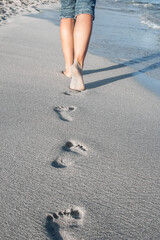 beautiful traces with feet near the sea on nature background