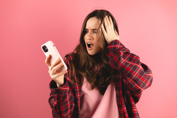 Photo portrait of panicking brunette woman with open mouth touching head holding phone in one hand...