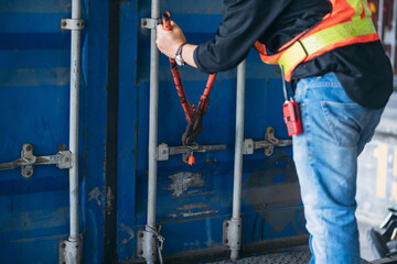 A man is using a red tool to open a blue container