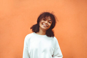 Pure happiness. Cute happy african american girl with curly hairstyle wearing white sweater posing...