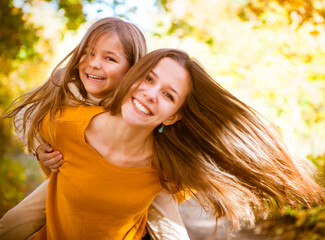 Obraz premium Two cheerful sisters playing in the park
