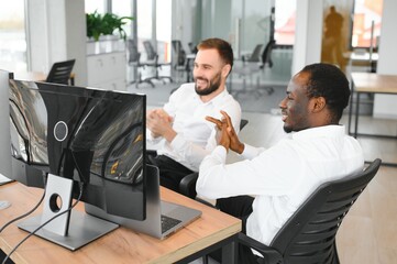 Two successful trader sitting in office, checking cryptocurrency information data on finance market graph, pointing on monitor