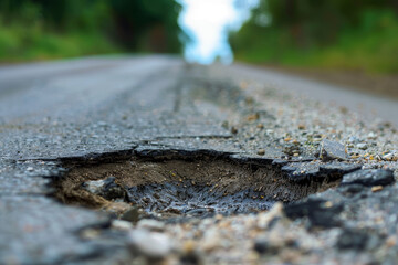 Fototapeta premium A pothole in the road with a lot of debris