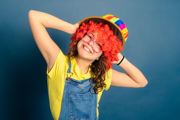animadora infantil con gorro de colores peluca roja y gafas rosa con nariz de payaso - obrazy, fototapety, plakaty