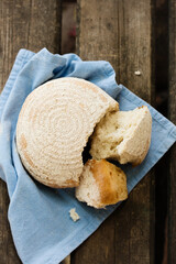 A round loaf of bread is broken