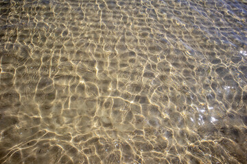 Clear sea water on a shoal near the shore on a beach holiday.