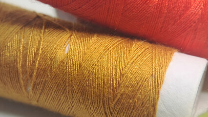 two spools of thread with orange and yellow colors