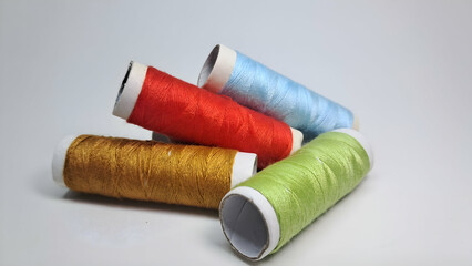 four spools of thread with different colors