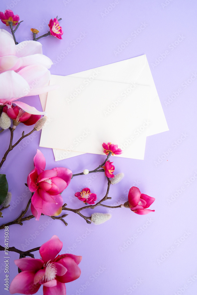 Poster blooming pink magnolia tree branch with flowers against violet background, copy space