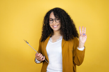 African american business woman with paperwork in hands over yellow background showing and pointing up with fingers number three while smiling confident and happy