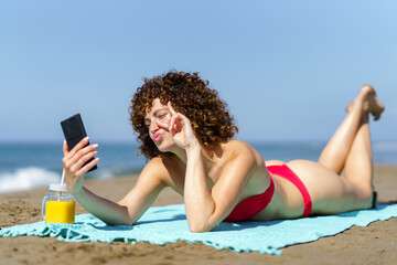Cheerful woman in bikini taking selfie on beach - 784716623