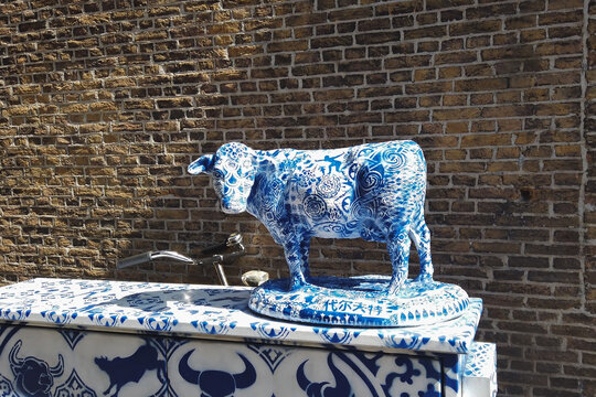 Delft, Netherlands - April 21, 2019 : Large ceramic sculpture of a Delft cow on one of the streets of Delft