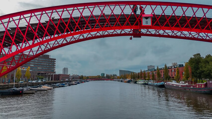 Aerial drone view of modern footbridge Python Bridge at Eastern Docklands neighborhood of Amsterdam...