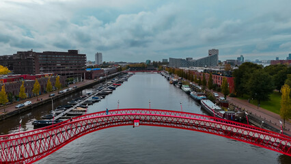 Aerial drone view of modern footbridge Python Bridge at Eastern Docklands neighborhood of Amsterdam...