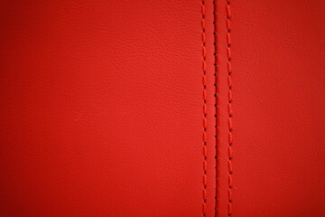 Red thread close-up on a blurred background of red leather car seat