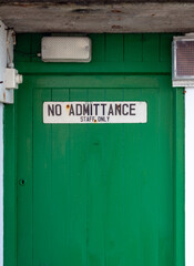 Staff only sign on a green door