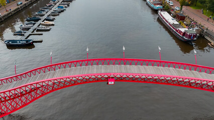 Aerial drone view of modern footbridge Python Bridge at Eastern Docklands neighborhood of Amsterdam...