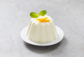 Lemon cream pudding on a plate. Light grey background. Close-up