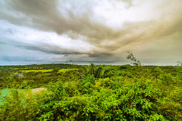 Expansive view of the Costa Rican landscape from Uvita, featuring lush greenery under a dramatic...