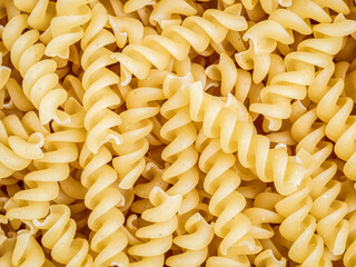 A pile of raw italian fusilli spiral pasta. Texture background.
