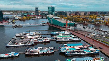 Aerial drone view NEMO museum in Amsterdam autumn cityscape narrow old houses, canals, boats bird's eye view
