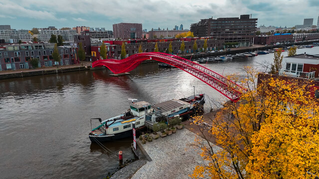 Aerial drone view of modern footbridge Python Bridge at Eastern Docklands neighborhood of Amsterdam Netherlands