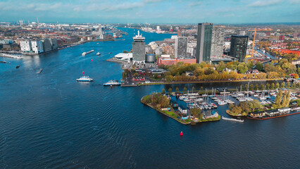 Obraz premium Aerial drone view Amsterdam autumn cityscape narrow old houses, canals, boats bird's eye view