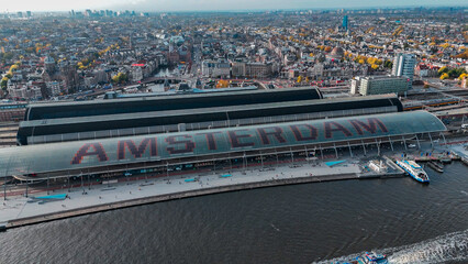 Aerial drone view Amsterdam Central Train Station with Amsterdam sign on roof. Bird's eye view...