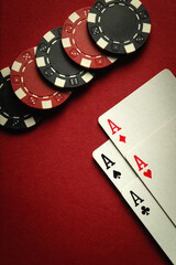 Card winning with a combination of aces four of a kind or quads and chips on a red table in a...