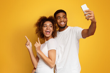 Happy african-american man and woman making selfie