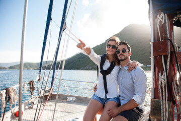 Happy couple traveling on yacht at sea. Man and woman hugging and having fun, adventures and...