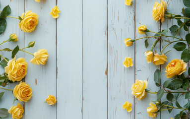 Obraz premium Flat lay frame with yellow roses with leaves and petals on a white wooden background. Top view