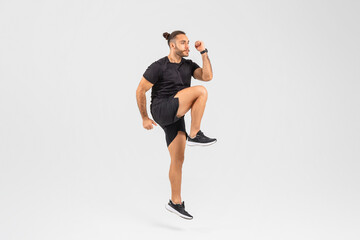 Man performing high knee exercise on white background