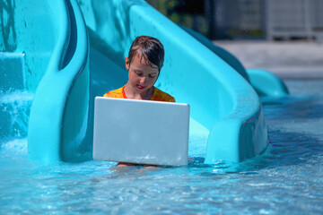 Learning and study everywhere and always concept. Young girl learning with laptop in the swimming...
