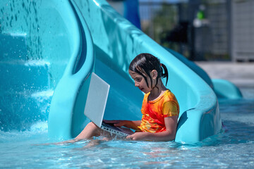 Learning and study everywhere and always concept. Young girl learning with laptop in the swimming pool. Horiazontal image. - obrazy, fototapety, plakaty