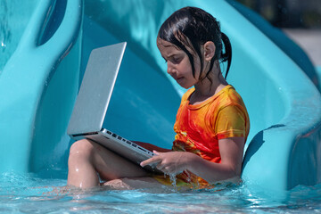 Learning and study everywhere and always. Young beautiful girl learning with laptop in the swimming pool. Horiazontal image. Horizontal image.
