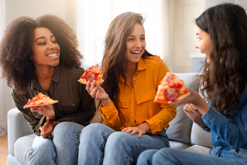 Multiracial friends enjoying pizza together at home - obrazy, fototapety, plakaty