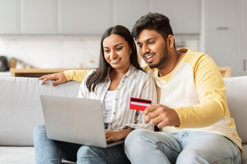 Couple making an online purchase with laptop - obrazy, fototapety, plakaty