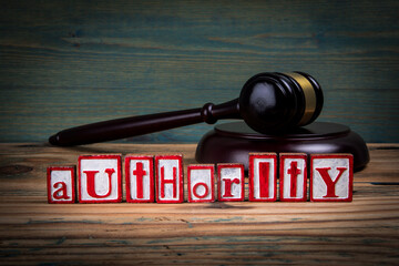 AUTHORITY. Red alphabet letters and judge's gavel on wooden background. Laws and justice concept