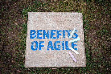 BENEFITS OF AGILE. Colored pieces of chalk on a concrete pavement slab - 784773848