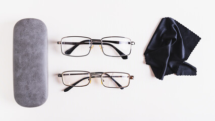 Whole glasses, broken glasses, hard case and cleaning cloth on table top view web banner
