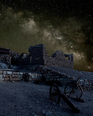 Galaxy milky way surrounded by stars with an abandoned bunker and cannon on foreground	