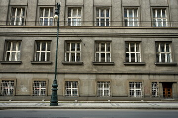 Alte Fassade eines Verwaltungsgebäude in Grau und Naturfarben mit vielen Fenstern und alter...