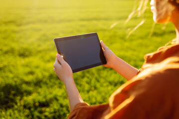 Smart farm. Woman Farmer with tablet in green field. Modern digital technologies. Agronomist at the...