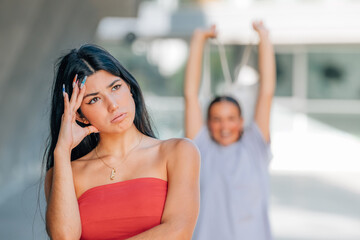 angry girl with her friend behind smiling happy