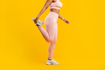 Active woman stretching leg in pink sportswear